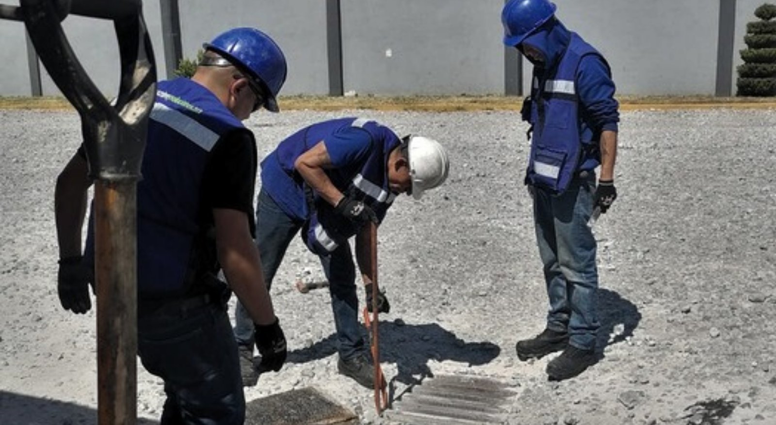 Técnicos de DEYSA inspeccionando una rejilla de drenaje